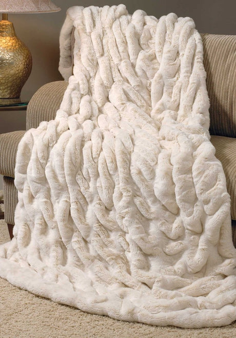 Ivory faux fur throw blanket on chaise